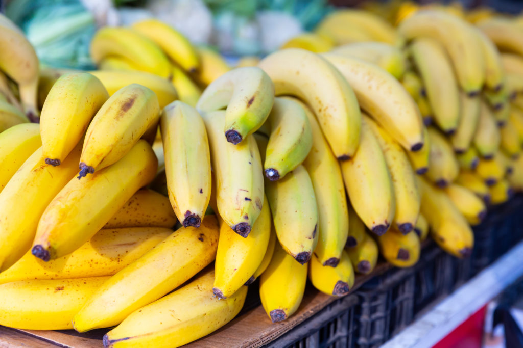 Showcase with ripe yellow bananas in greengrocery